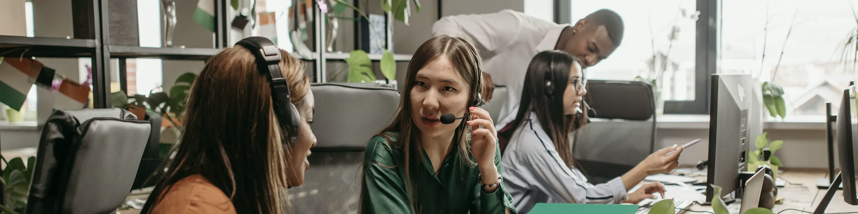 Two support agents with headsets working at their desks